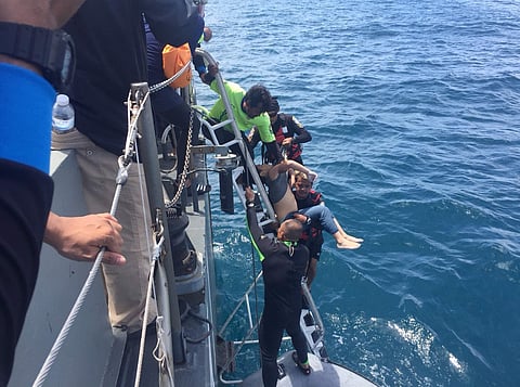 Divers on a rubber raft retrieve a body during a search operation in the water off Phuket, Thailand, Friday, July 6, 2018. (Photo: AP)
