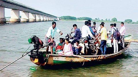 Locals cross Devi river on a boat near the incomplete bridgeI Express