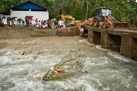 People who came to see the flood affected areas standing dangerously closed to the collapsing side wall of the water stream at Kannappankundu in Kozhikode.  (Photo | Manu R Mavelil/EPS)
