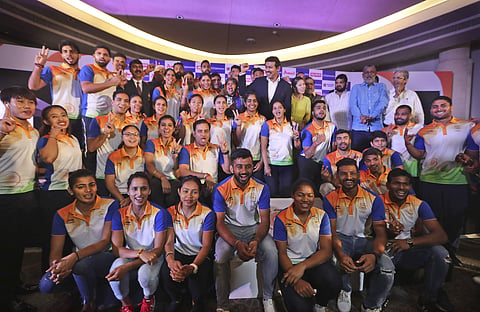 Sports minister Rajyavardhan Singh Rathore (cente right in black suit) stands with the Indian contingent for the 18th Asian Games during their send-off ceremony in New Delhi. (Photo | AP)