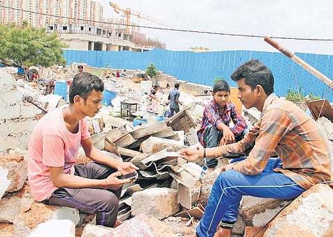 Residents of Gachibaowli’s Keshavnagar sit amid the rubble of what were once their homes on Tuesday. As many as 200 structures were removed.  | (S Senbagapandiyan | EPS)