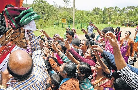 People affected by floods jostle to get relief materials at a camp held in Madapur, Kodagu, on Tuesday | pushkar V