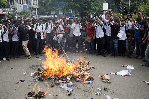 Bangladeshi students burn an effigy of Bangladesh's Shipping Minister Shahjahan Khan, who is also a transport workers' leader, as they block a road during a protest in Dhaka, Bangladesh. (Photo | AP)