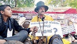 Magician Manu Mankombu chaining himself in a symbolic protest against the cancellation of festivals in connection with the flood,  in front of the Secretariat on Wednesday  Vincent Pulickal