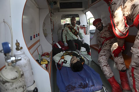 In this photo provided by the Iranian Students' News Agency, ISNA, wounded military personnel are carried into an ambulance after a shooting during a military parade marking the 38th anniversary of Iraq's 1980 invasion of Iran, in the southwestern city of
