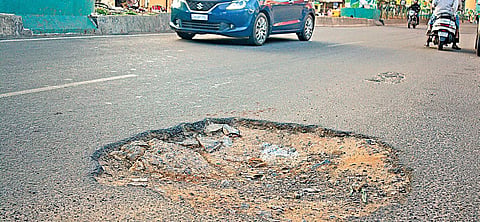 A pothole-ridden road near Ulsoor on Sunday; (below) workers undertake asphasting work on a road | Pandarinath B