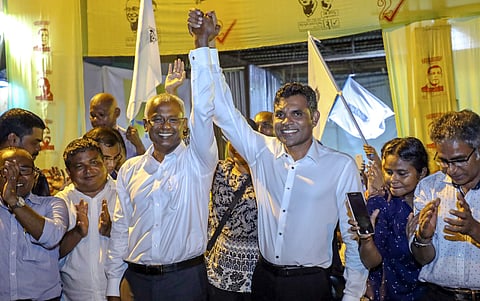 Ibrahim Mohamed Solih, third left, and his running mate, Faisal Naseem, third right, pose for photographers as they celebrate their victory | AP