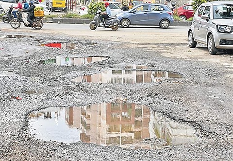Potholes surfaced on a newly asphalted road near Bannerghatta after heavy rains  | Nagaraja Gadekal