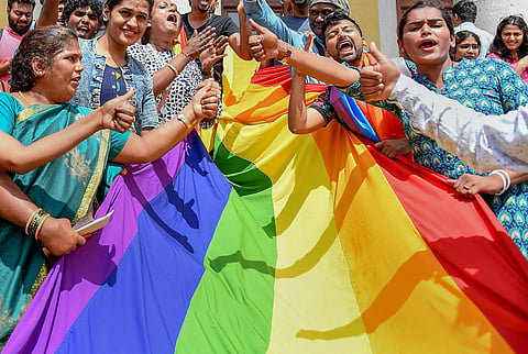 LGBTQ community people with a rainbow flag celebrate the Supreme Court verdict which decriminalises consensual gay sex in Bengaluru. (Photo | PTI)