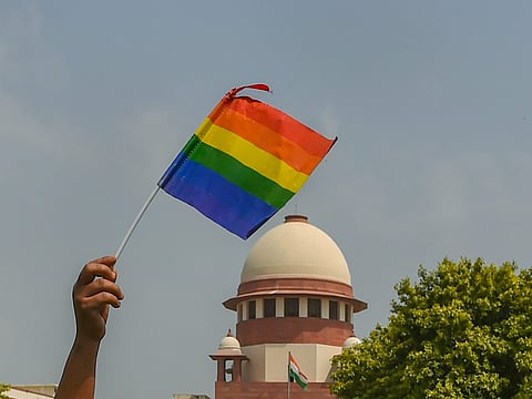 An activist waves a rainbow flag LGBT pride flag after the Supreme Court verdict which decriminalises consensual gay sex outside the Supreme Court. (File | PTI)