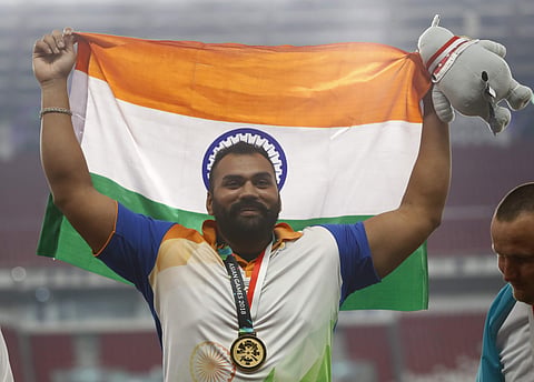 Tejinder Pal Singh Toor celebrates on the podium after receiving his gold medal for the men's shot put | AP