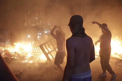 Anti-government protesters set fire to plastic barriers and trash to block a road during a demonstration in Beirut, Lebanon. (Photo | AP)