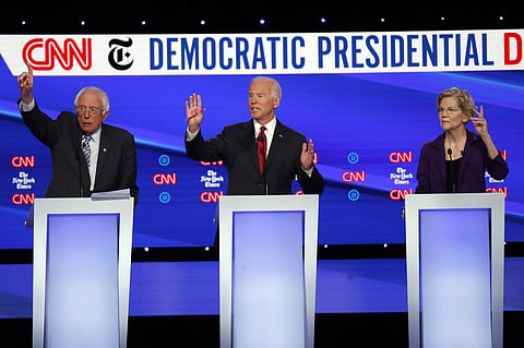Democratic presidential candidate Sen. Bernie Sanders, I-Vt., left, former Vice President Joe Biden, center, and Sen. Elizabeth Warren, D-Mass., raise their hands to speak during a Democratic presidential primary debate hosted by CNN/New York Times at Ott