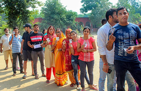 File - Voters stand in a queue to cast their votes at a polling station during Haryana Assembly elections. 