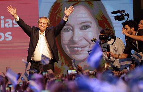 Presidential candidate Alberto Fernández waves to supporters in front of a large image of his running mate, former President Cristina Fernández, after incumbent President Mauricio Macri conceded defeat at the end of election day in Buenos Aires, Argentina