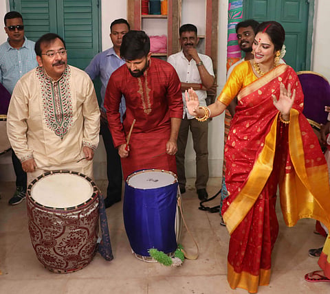 Actress and Trinamool Congress MP Nusrat Jahan dances as her husband Nikhil Jain (C) and West Bengal Sports Minister Arup Biswas (L) play drums during the ongoing Durga Puja festival in Kolkata Sunday Oct. 6 2019. | (Photo | PTI)