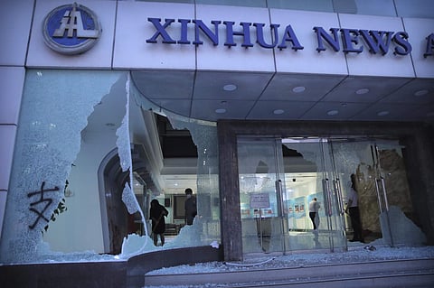 People stand inside the lobby of China's Xinhua News Agency damaged by protesters in Hong Kong, Saturday, Nov. 2, 2019.  (Photo | AP