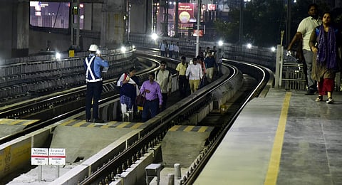 Passengers walking through the track to reach the metro station after a train between Ameerpet and Begumpet stopped due to short circuit (Express/Vinay Madapu)