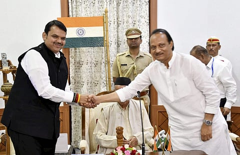 Newly sworn in Chief Minister of Maharashtra Devendra Fadnavis shakes hands with his Deputy Chief Minister Ajit Pawar in Mumbai Saturday Nov. 23 2019. (Photo | PTI)