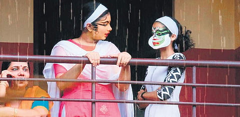Kathakali participants sharing a light moment before their performance (R)  A kathakali artist quenching her thirst