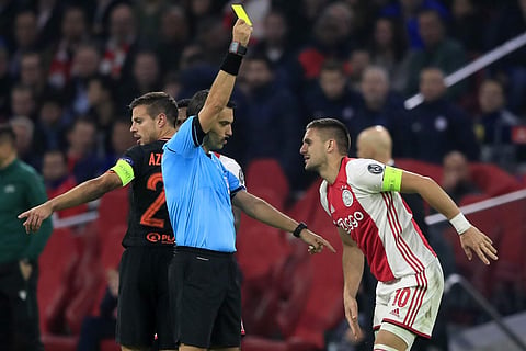 Ajax's Dusan Tadic is shown a yellow card after a foul on Chelsea's Willian. (Photo | AP)