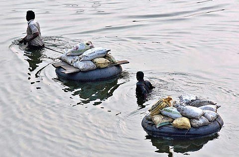 Two persons cart out sand they collected from the middle of River Krishna in Vijayawada  on Wednesday | P Ravindra Babu
