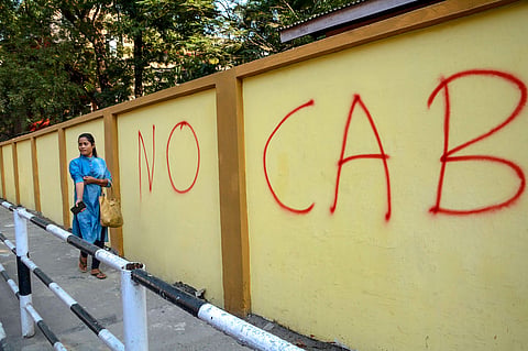 A pedestrain walks past a wall graffiti opposing the Citizenship Amendment Bill CAB in Guwahati. (Photo | PTI)