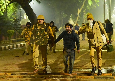 Aligarh Police take away a student after clashes following protests over Citizenship Amendment Act on the campus of Aligarh Muslim University late Sunday night Dec. 15 2019. (Photo | PTI)