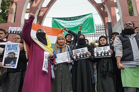 Protestors including students and local residents hold placards during a demonstration against the Citizenship Amendment Act outside Jamia Millia Islamia University (Photo| PTI)