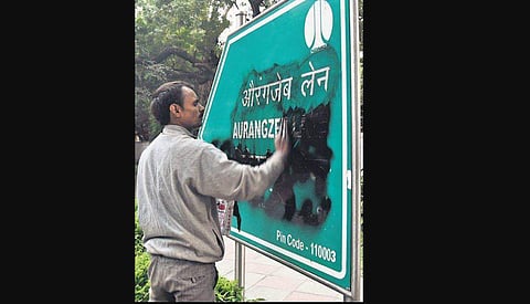 An NDMC worker cleans a board bearing the name of Aurangzeb Lane. ( Photo|Parveen Negi, EPS)