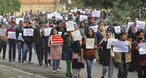 Jamia teachers and staff display placards during a peaceful protest march against the Citizenship Act in New DelhI. (File Photo)