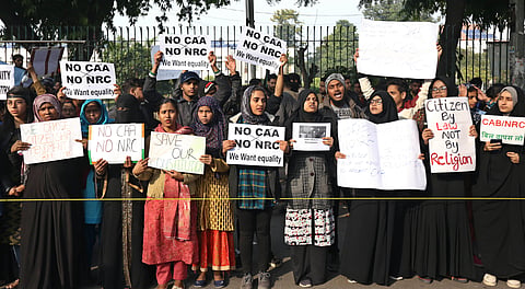 Protestors including students and local residents hold placards during a demonstration against the Citizenship Amendment Act outside Jamia Millia Islamia University. (File | EPS)