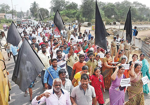 Farmers and villagers walking in a protest rally with black flags at Mandadam village in Amaravati on Thursday I express
