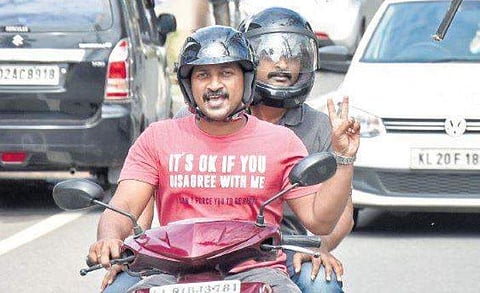 A two-wheeler rider shows the victory sign upon seeing the  camera at Ambujavilasam Road B P Deepu
