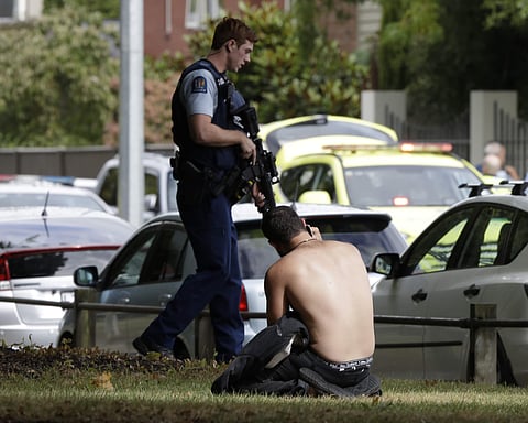 An attack on two crowded mosques during Friday prayers left multiple people dead, police said, on what Prime Minister Jacinda Ardern described as 'one of New Zealand's darkest days'.  IN PIC: A man rests on the ground as he speaks on his mobile phone acro