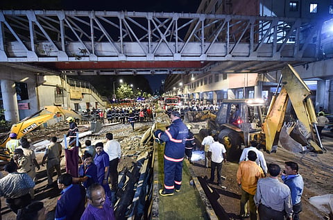 Rescue worker clear away debris of a collapsed foot overbridge in south Mumbai. (Photo | PTI)