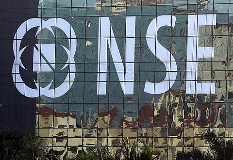Buildings are reflected on the glass windows of the NSE (National Stock Exchange) building in Mumbai. (File photo | Reuters)