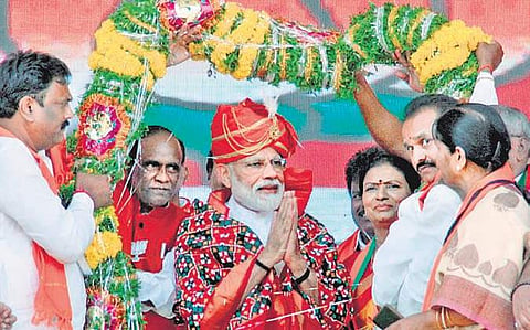 Prime Minister Modi being garlanded by party activists in Mahbubnagar on Friday | S.Senbagapandiyan