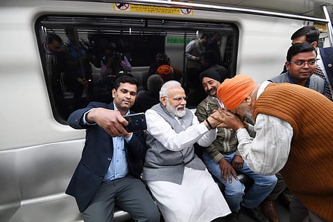 PM Modi interacting with passengers while taking the Metro train from Shaheed Sthal. (Photo: Narendra Modi, Twitter)