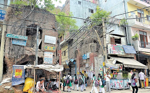Old structures are flanked by multi-storey buildings on either sides at Chiragh Delhi.