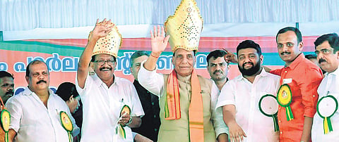 Union Home Minister Rajnath Singh and NDA candidate P C Thomas wave at the audience during a poll-related meeting held at Nagambadom ground in Kottayam on Saturday. Kerala Janapkasham leader PC George is seen
