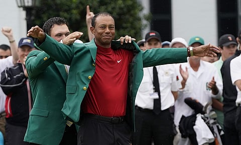 Patrick Reed helps Tiger Woods with his green jacket after Woods won the Masters golf tournament Sunday, April 14, 2019, in Augusta, Ga. | AP