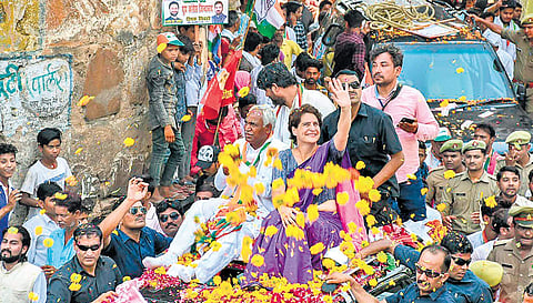 Congress general secretary Priyanka Gandhi Vadra waves at supporters during an election campaign roadshow in support of party candidate Shiv Sharan Kushwaha (to Priyanka’s right) in Jhansi, Uttar Pradesh, on Thursday | PTI