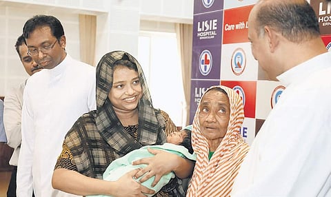 Jamsheela, along with her eight-day-old  infant who successfully underwent the first phase of cardiac treatment at Lisie Hospital, with the doctors after the press conference at the hospital on Thursday (Photo | Arun Angela)