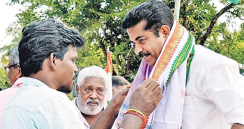 A party worker garlanding Adoor Prakash. (Photo | Vincent Pulickal)