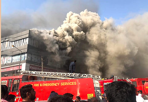 Smoke billows from the Taxshila Complex after a fire engulfed the third and fourth floor of the coaching centre in Surat Friday May 24 2019. (Photo | PTI)