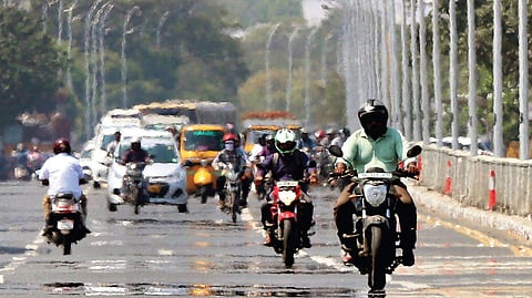 Motorists suffering from the blistering sun which creates a mirage on road at Kamarajar Salai in city  | Ashwin Prasath