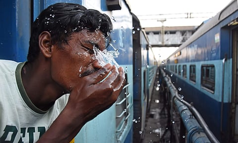 A passenger sprinkles water on his face at the railway station. (Photo| EPS)