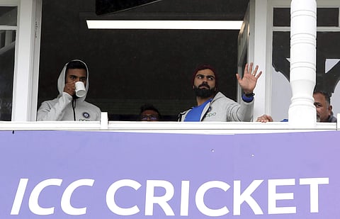 Virat Kohl, right, with teammate stands in the players pavilion as rain delays start of the Cricket World Cup match between India and New Zealand at Trent Bridge in Nottingham. (Photo | AP)
