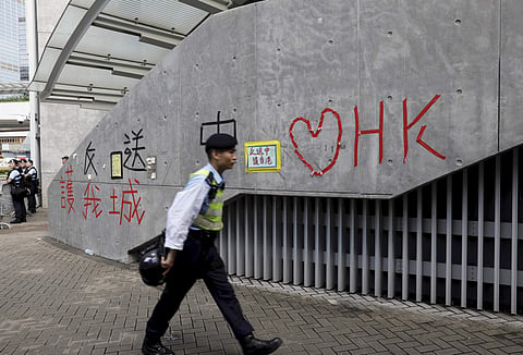 A police officer passes by 'Love Hong Kong' words formed with tape near the Legislative Council in Hong Kong. (Photo| AP)